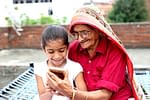 Grandchild and grandmother using Smartphone