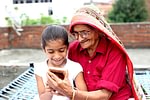 Grandchild and grandmother using Smartphone